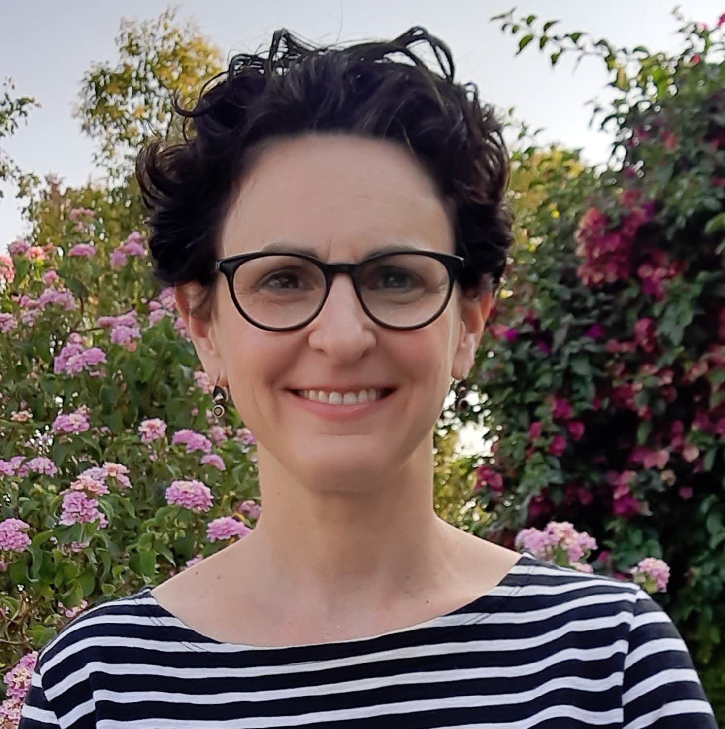 Alexis Manheim standing in front of flowers